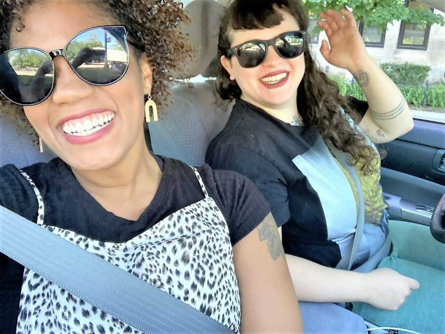 two adult girl friends hanging out in a car taking a selfie