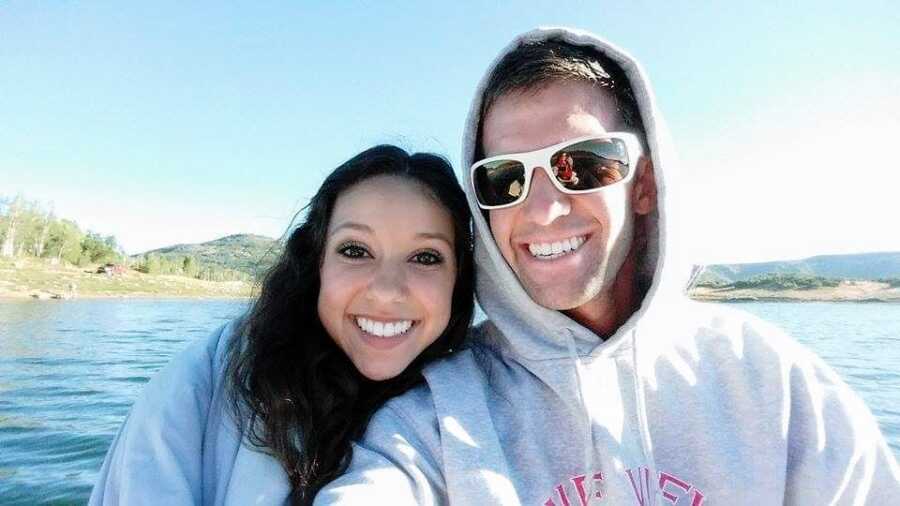 A woman with her husband outside, both are wearing grey sweatshirts