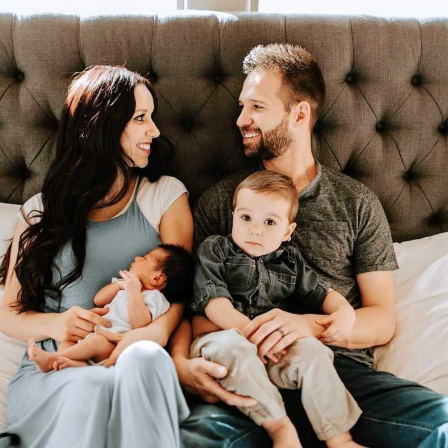 A mom sits with her husband and two kids