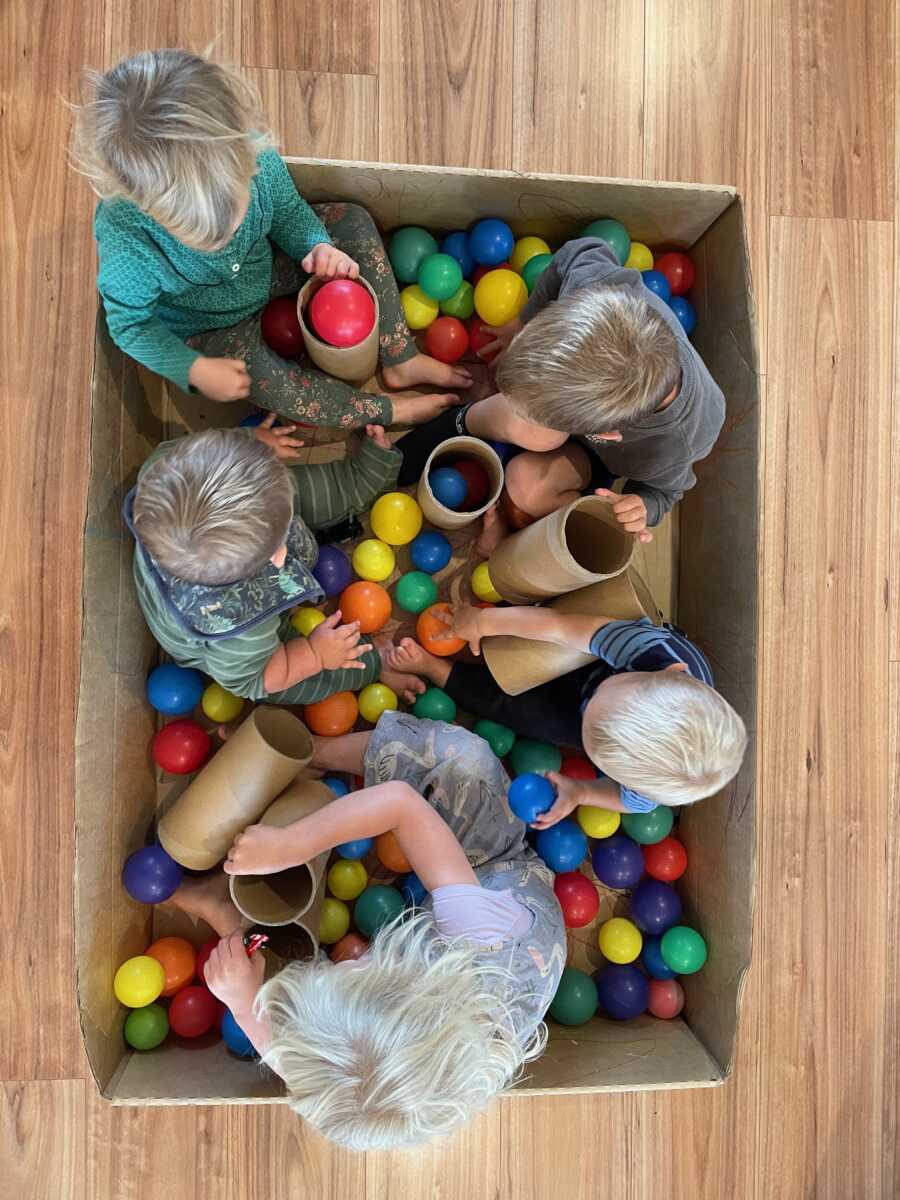 Top view of young siblings playing in ball pit together.