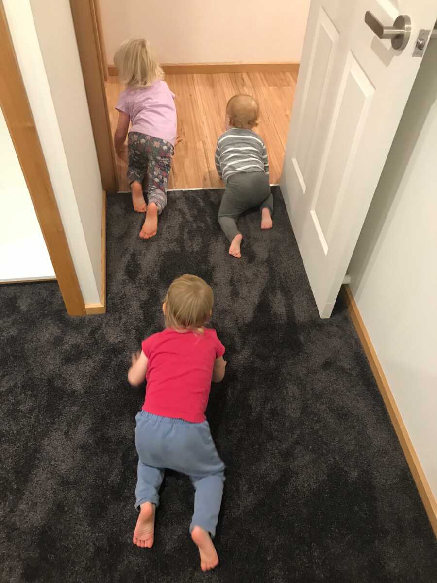 Sister crawls following siblings through the door.