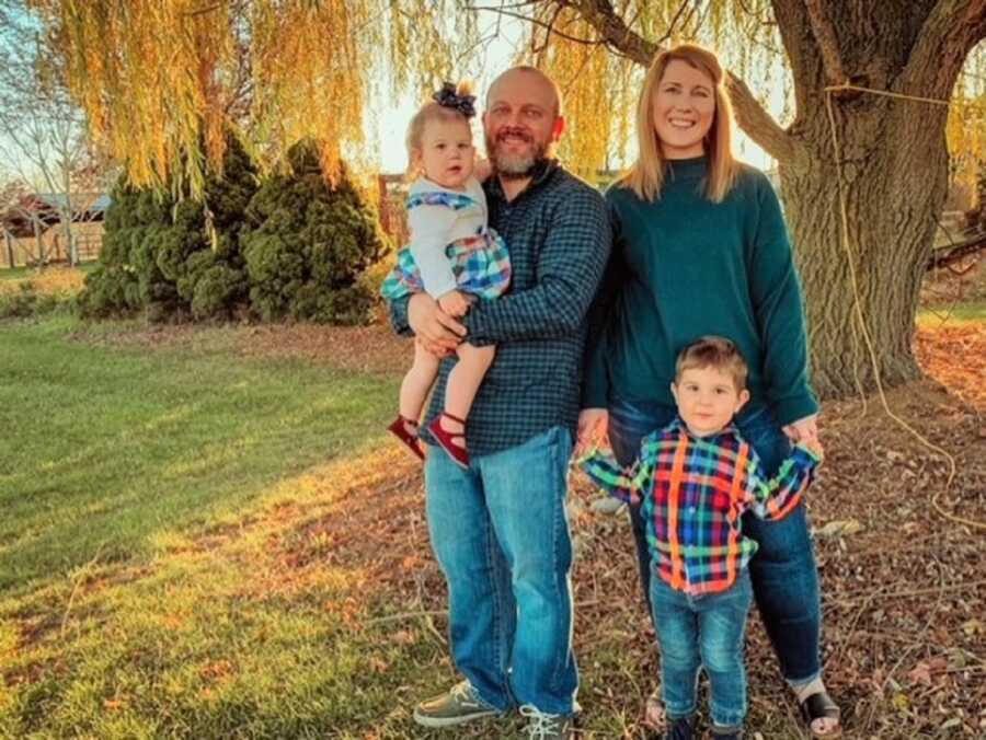Adoptive parents take fall family picture with their two young children.
