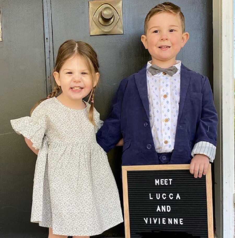 Foster siblings hold up letter board introducing themselves after adoption.