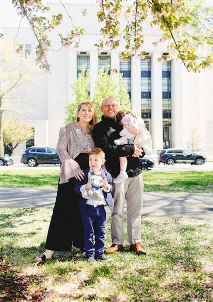 Family takes picture outside court room after finalizing adoption.