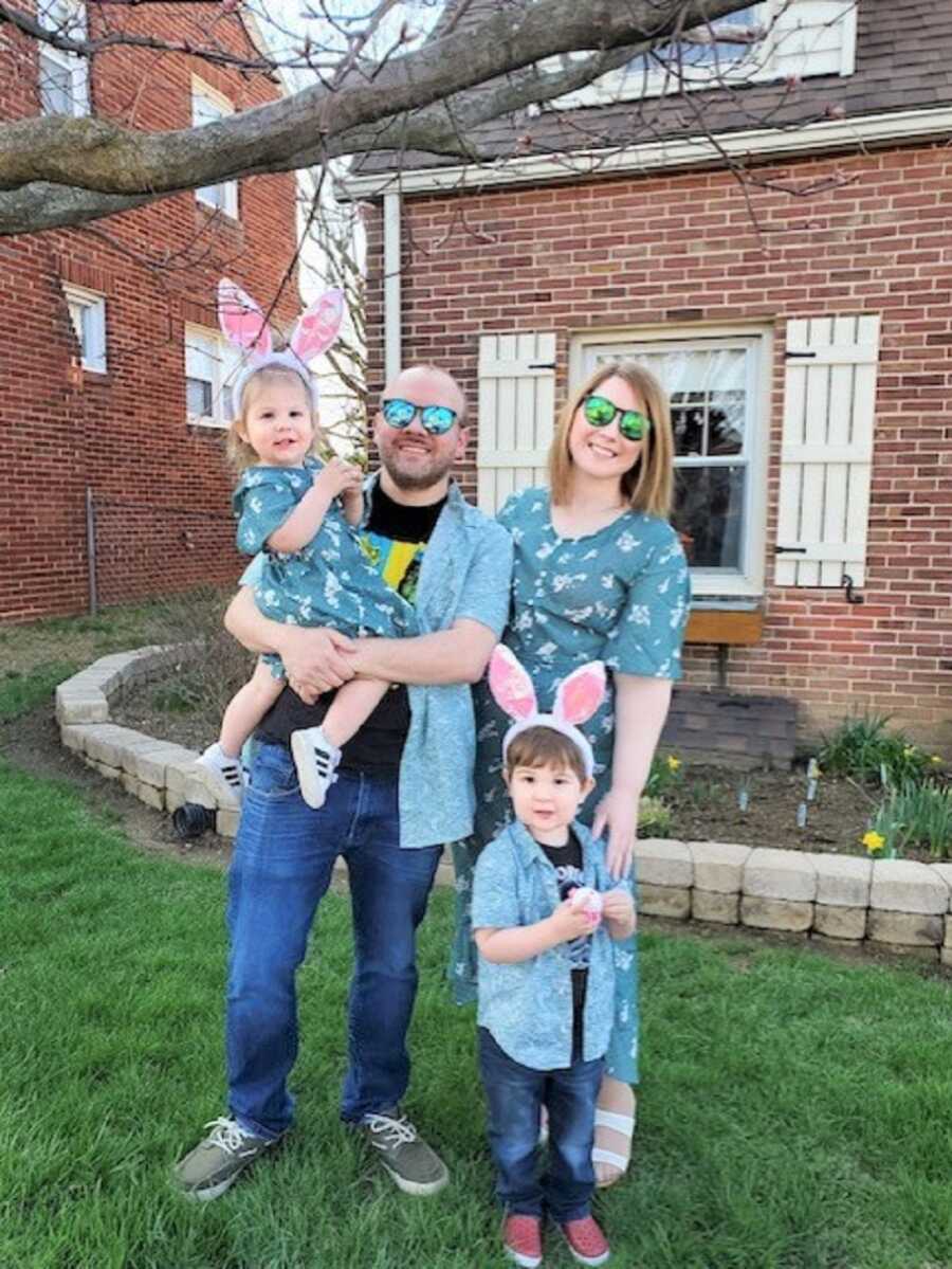 Foster parents take picture with young siblings wearing Easter bunny ears.