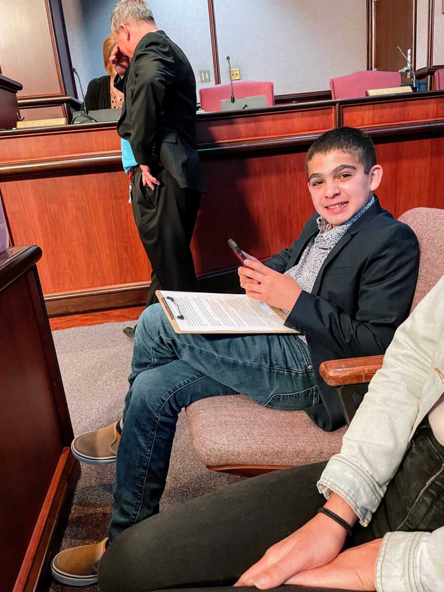 A boy with autism reviews his notes before giving a speech