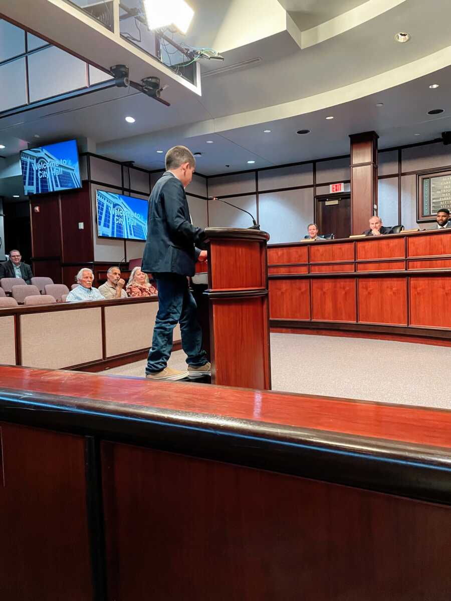 A boy with autism giving a speech to the city council