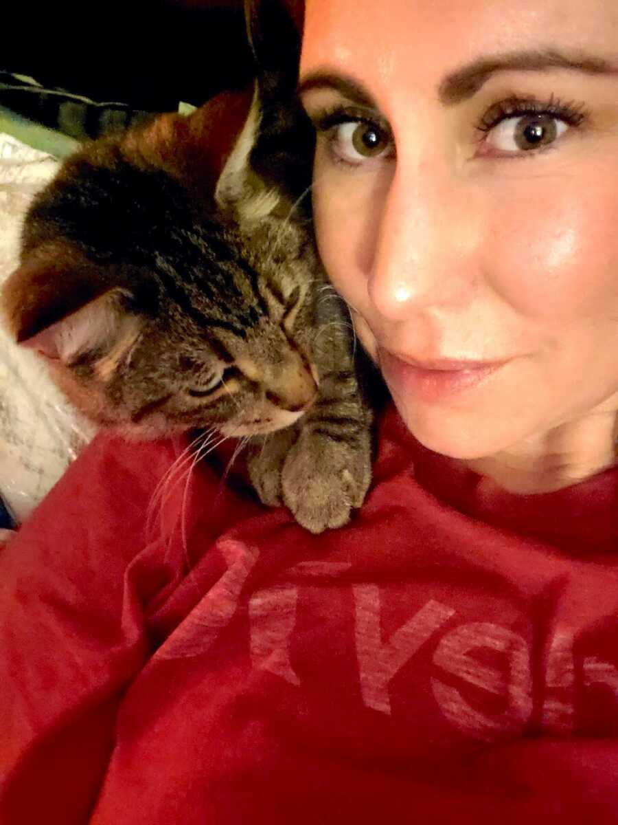 woman who is recovering from substance abuse takes a selfie with her cat