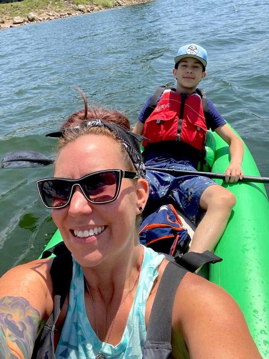 woman in addiction recovery rides in a kayak with her son