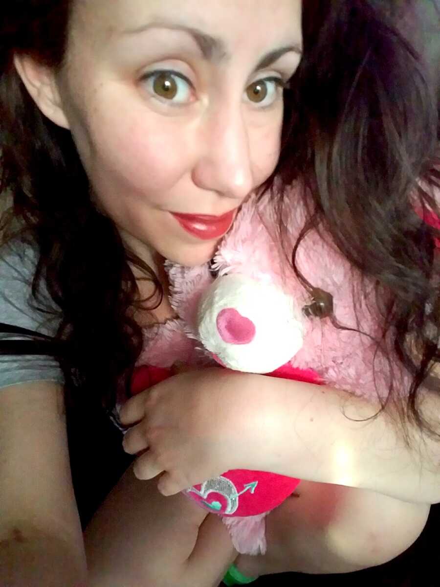 woman with addiction hugs a teddy bear and takes a selfie