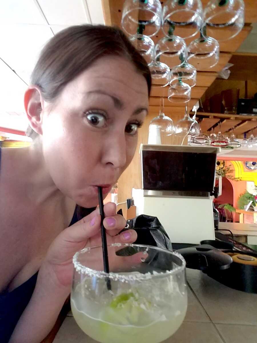 alcoholic woman takes a selfie while drinking at the bar