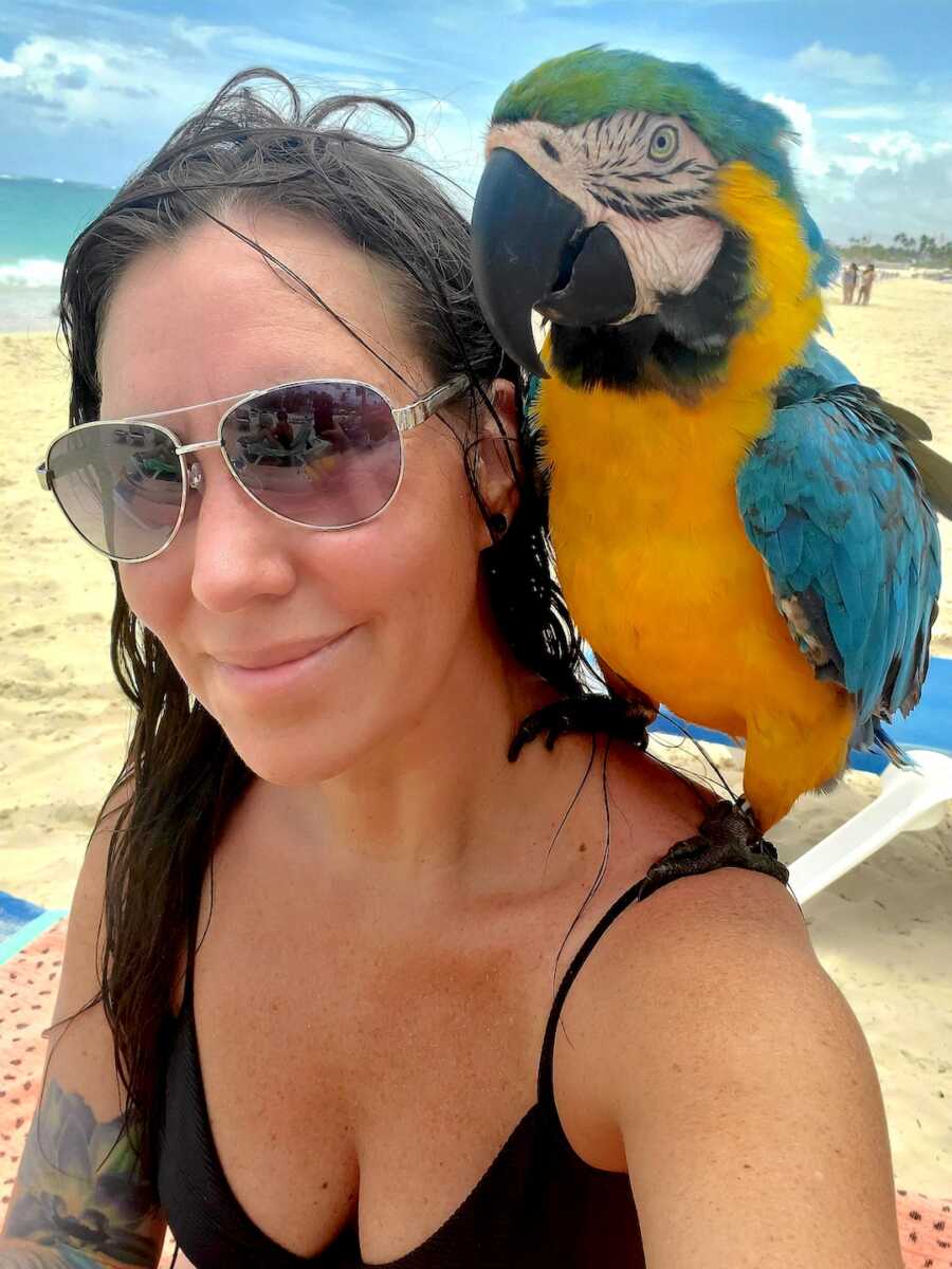 woman in recovery takes a selfie with a bird on her shoulder