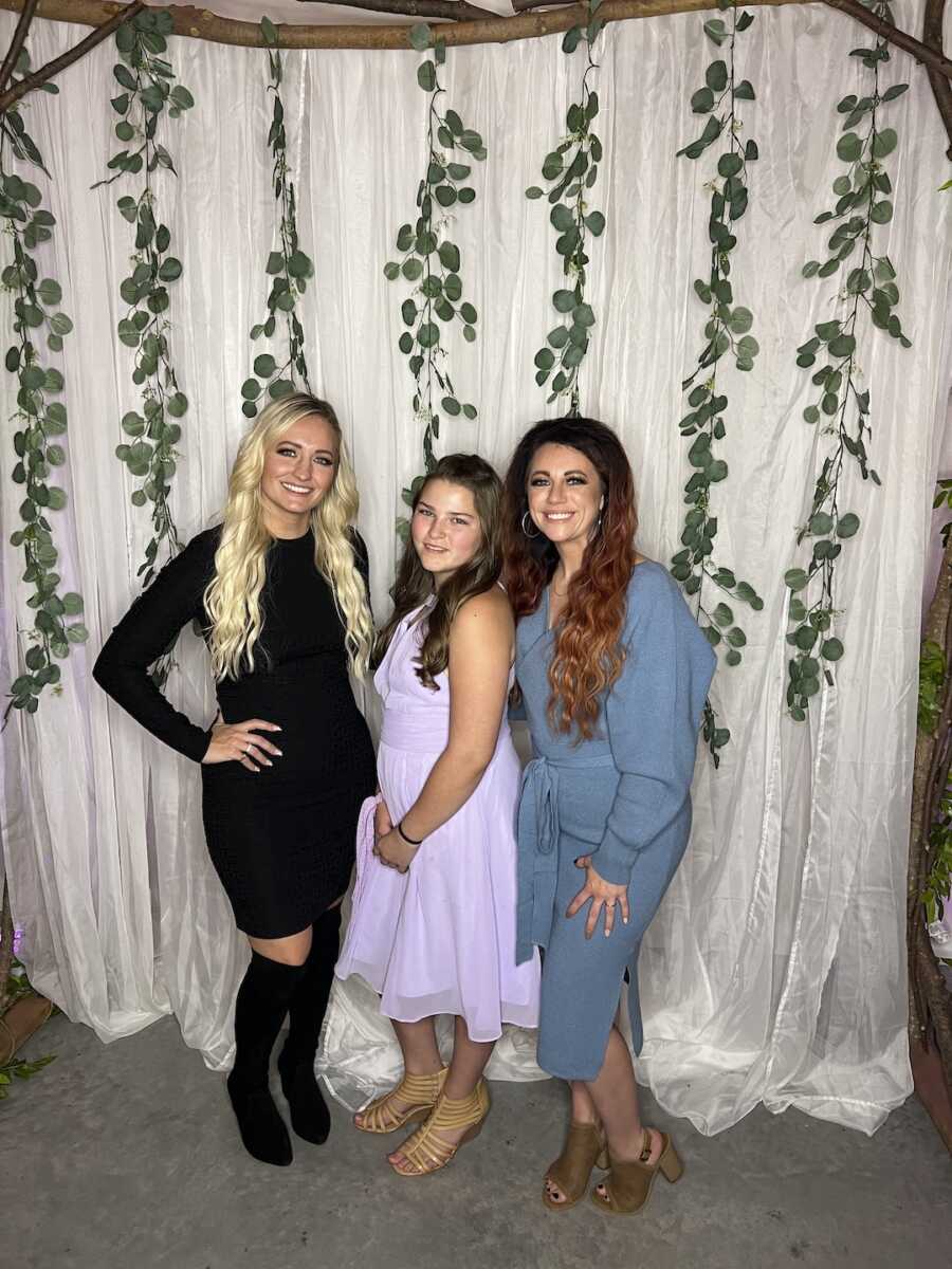 Cousin poses with adoptive mom and daughter at wedding.
