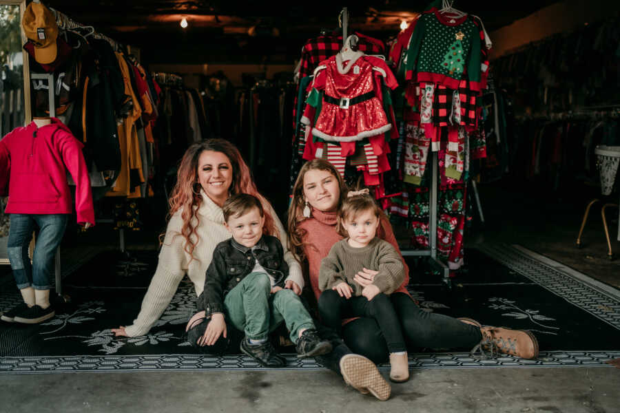 family sits on the floor of their store, The Adopted Closet