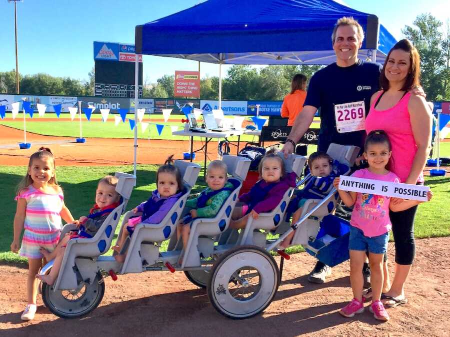 Father stands with his quintuplets, children and wife at a full marathon