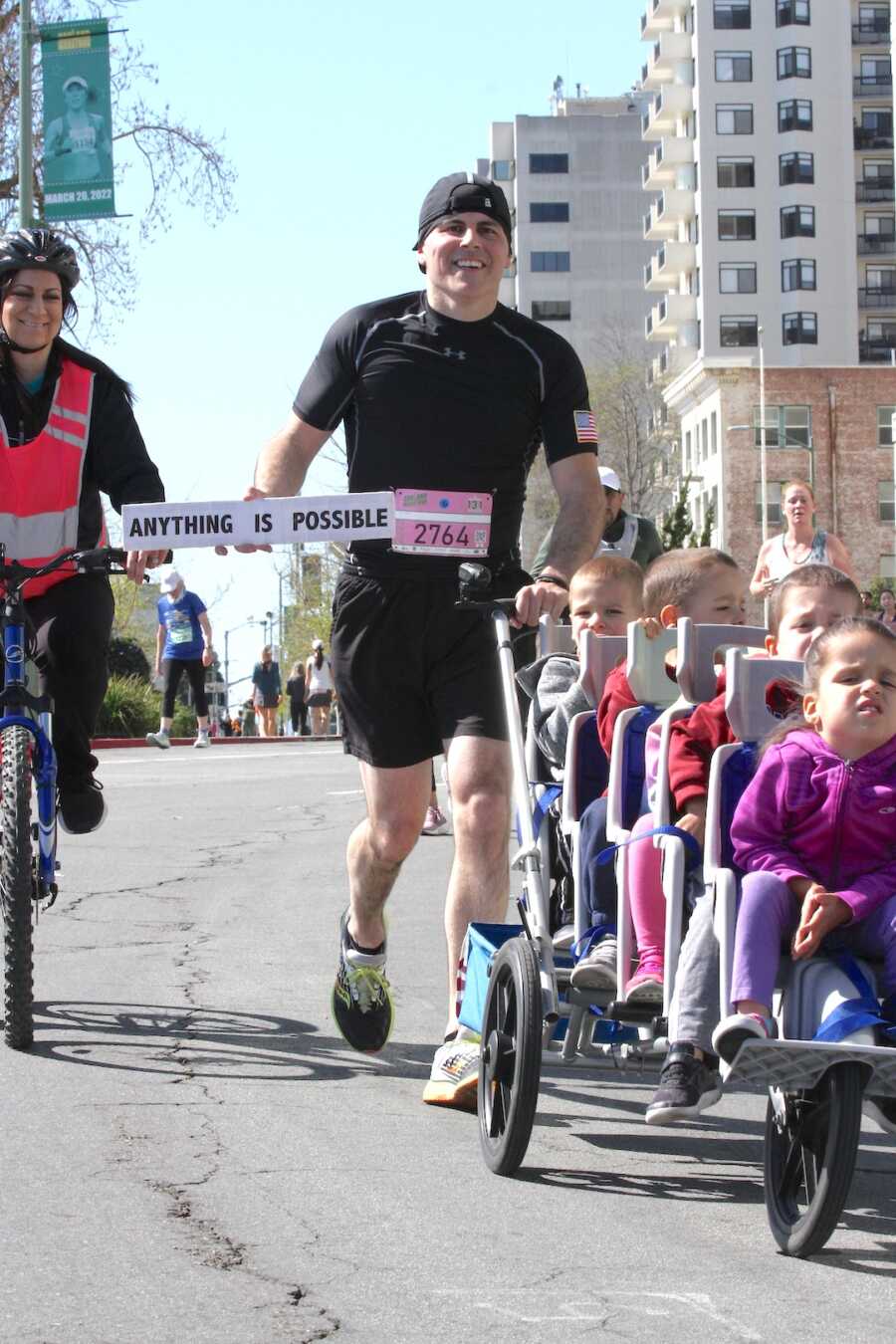 dad runs half marathon pushing quintuplets to honor wife, while she bikes alongside