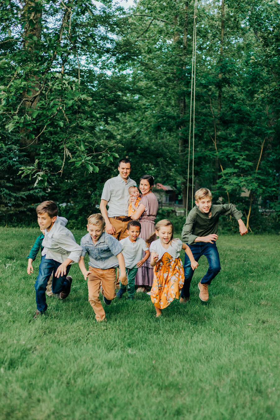 parents smiling while children are running in the front