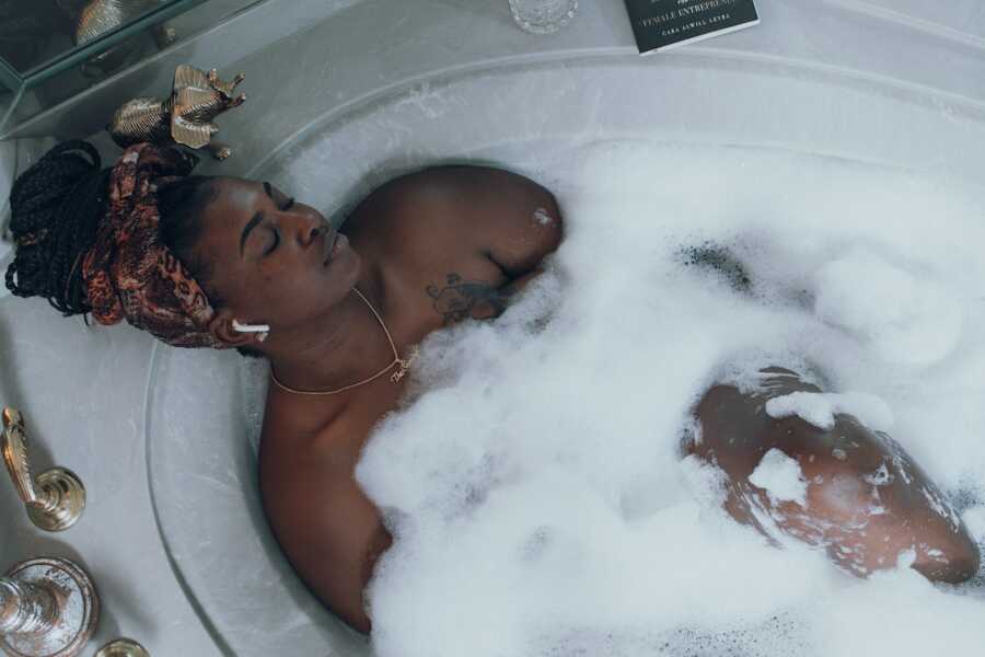 woman sits relaxing in a bath