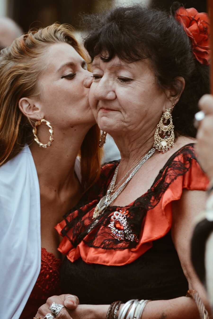 daughter gives her mother a kiss on the cheek