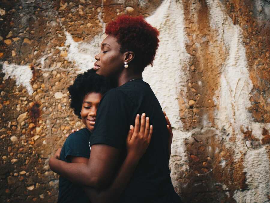 mom pulls her daughter in to embrace her