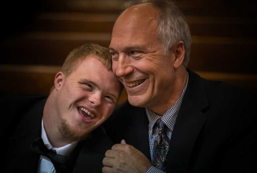 special needs son rests his head on his dad's shoulder