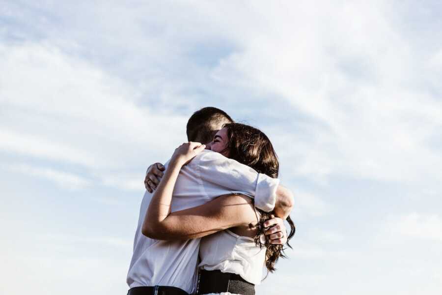 husband and wife embrace each other in a hug