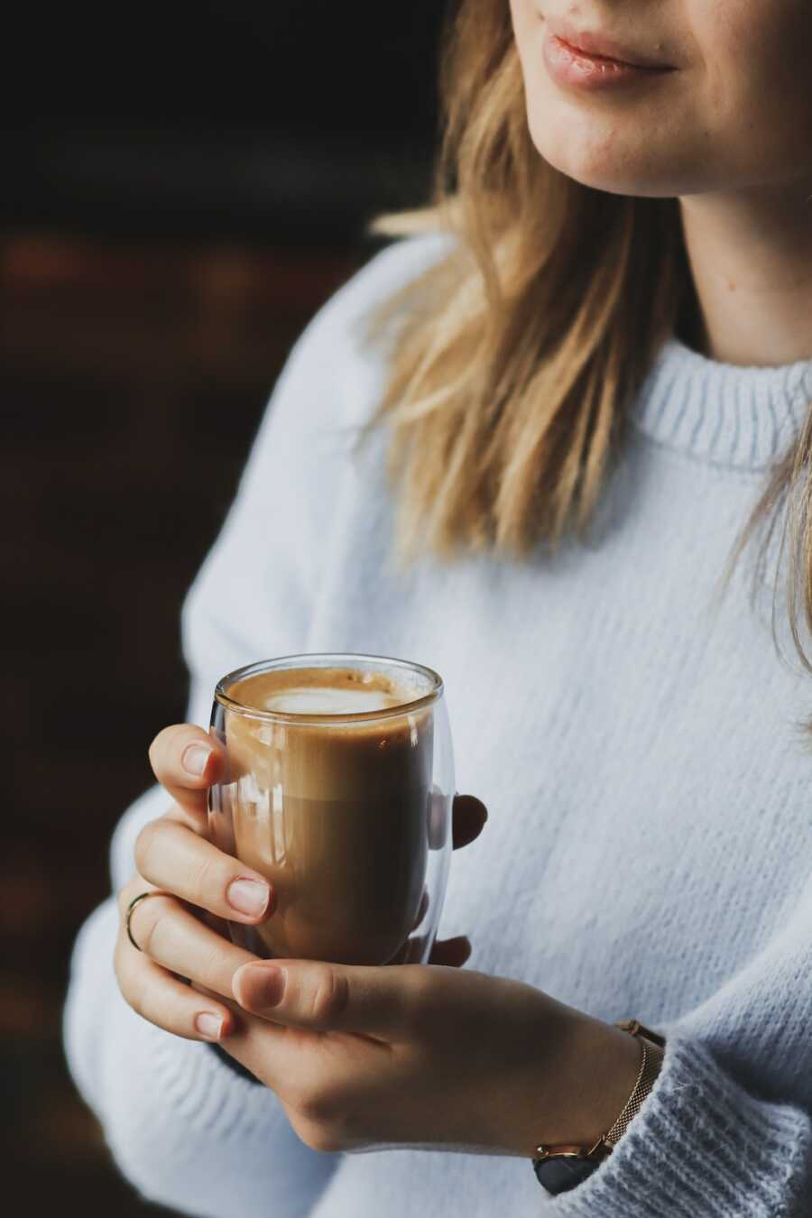 woman holds a cup of coffee in her hands