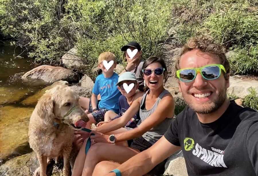 foster parents and three foster children on a hike with their dog