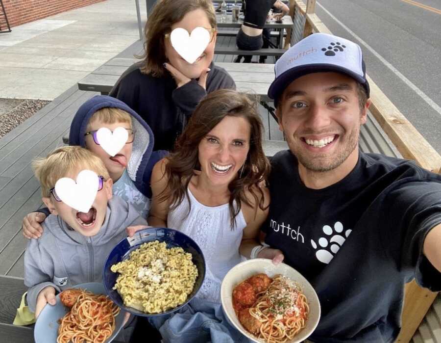 foster parents eat pasta with three of their foster children