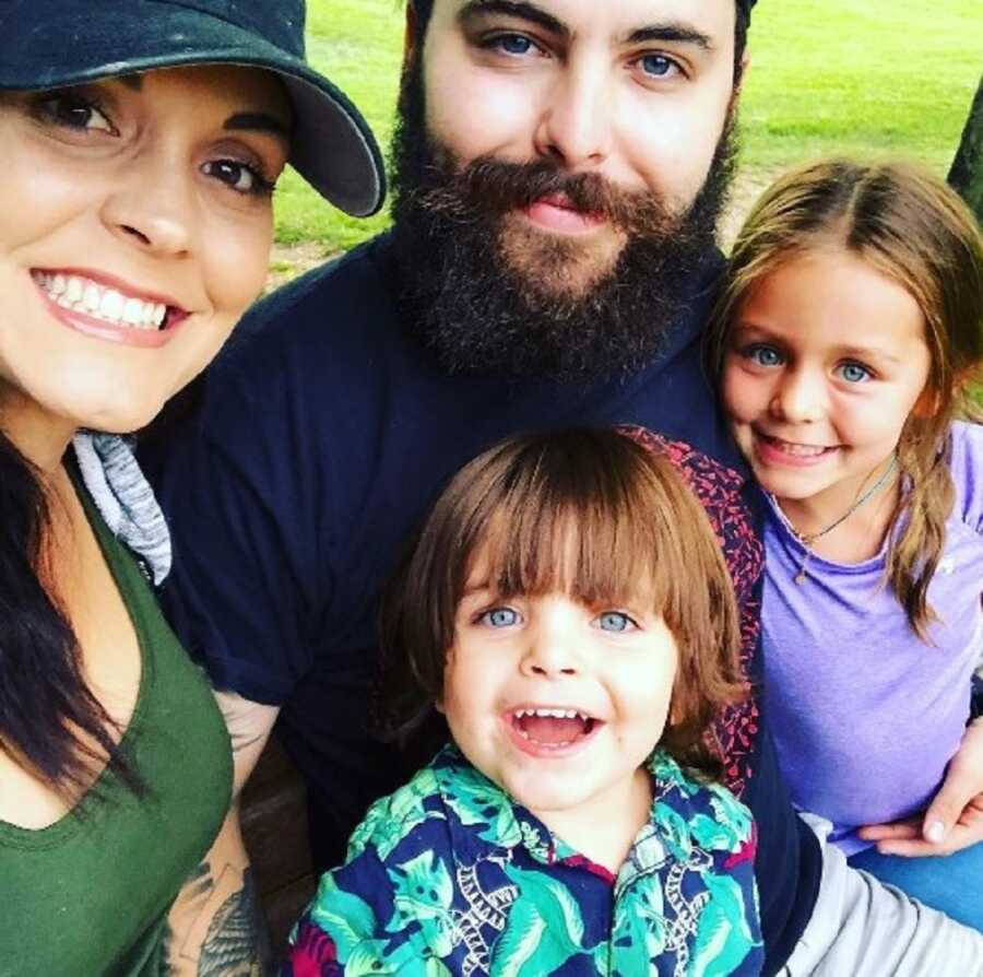Couple takes selfie with their two young children.