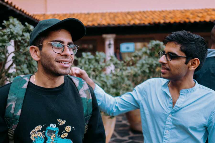 friend consoles his friend with hand on shoulder