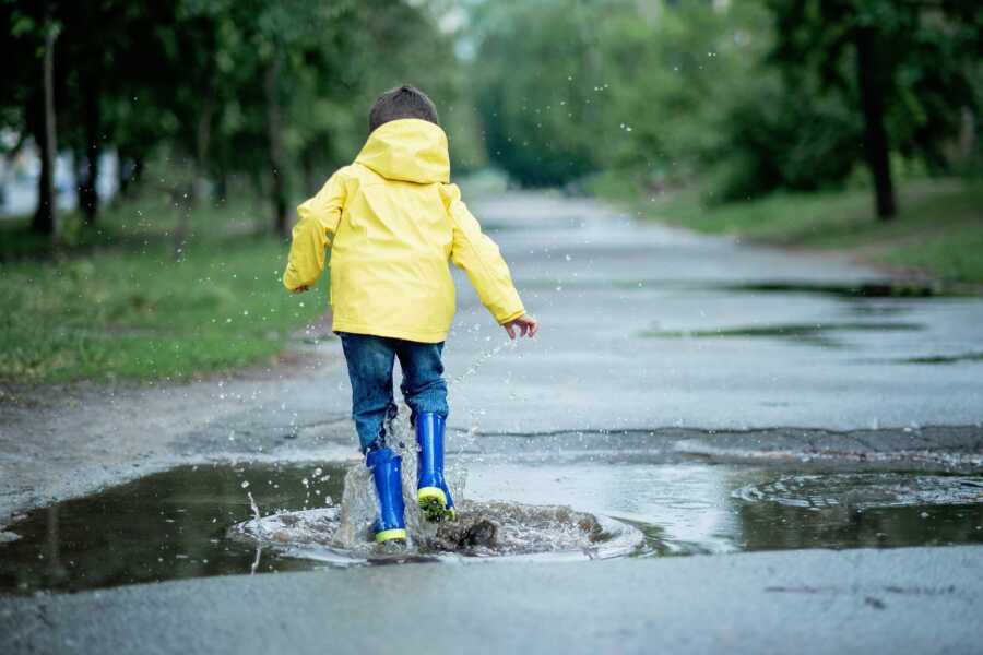 kid playing in a puddle