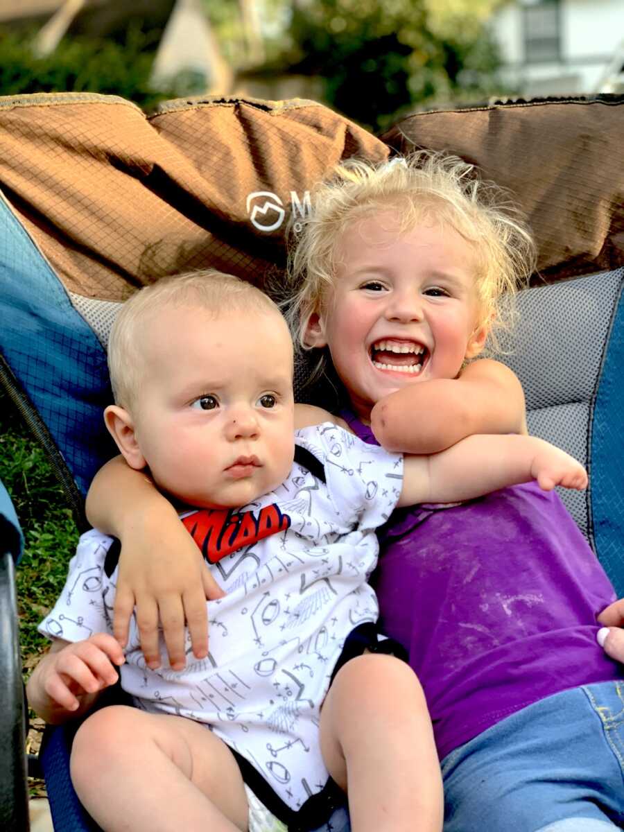 two children with limb differences sit together