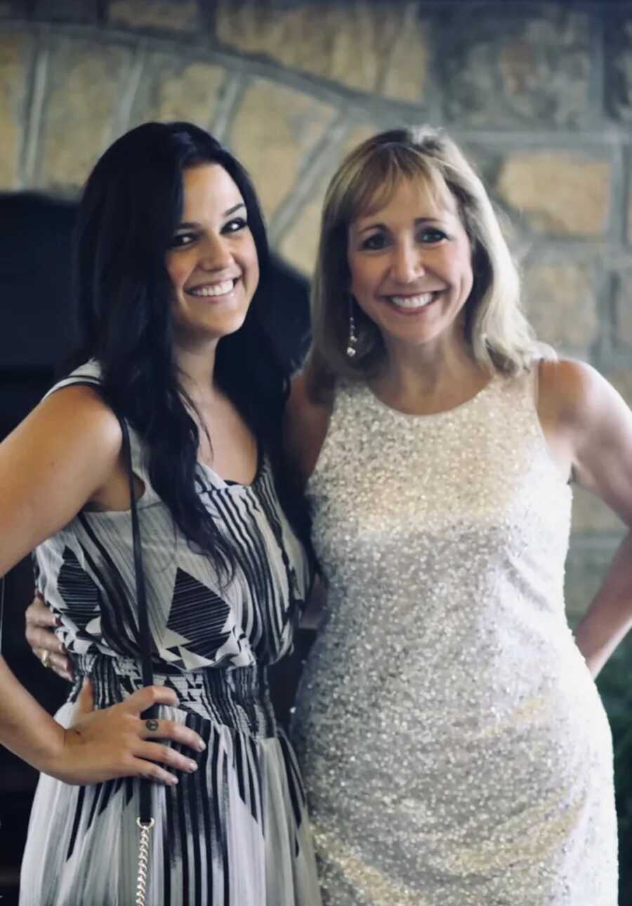 Daughter and mom standing together smiling 