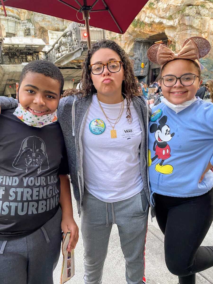 mother stands at Disney with her two kids