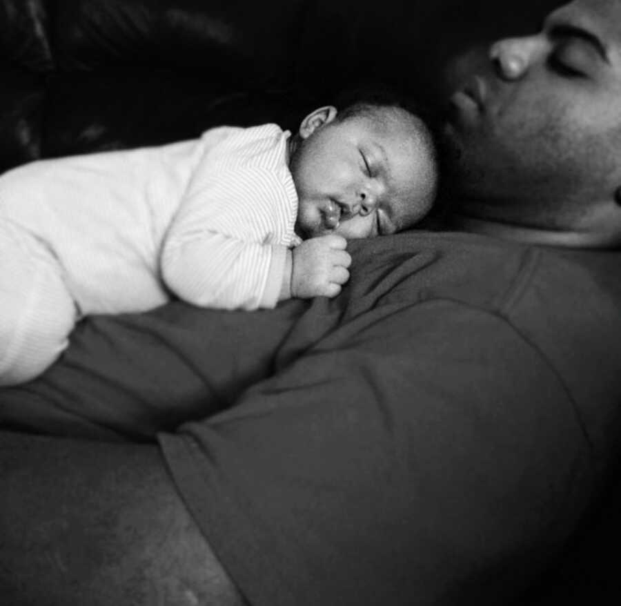 father lays on back with his child on his chest
