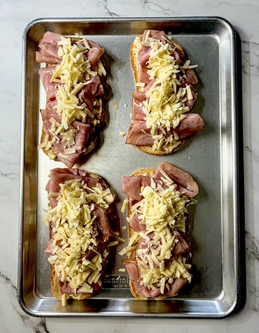 bread slices layered with cheese ham and then more cheese on top