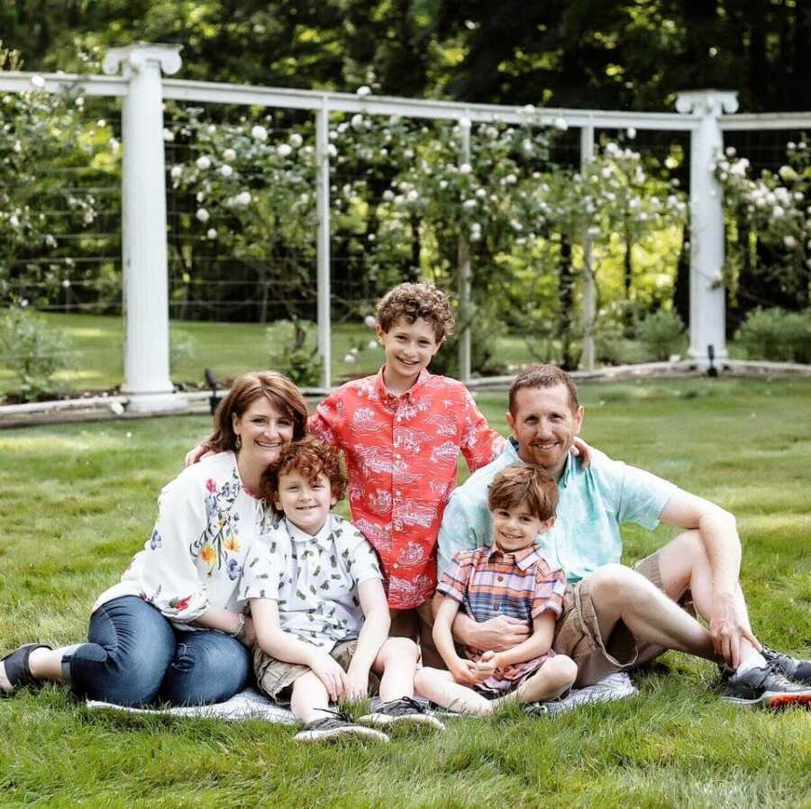 A family of five sitting outside together