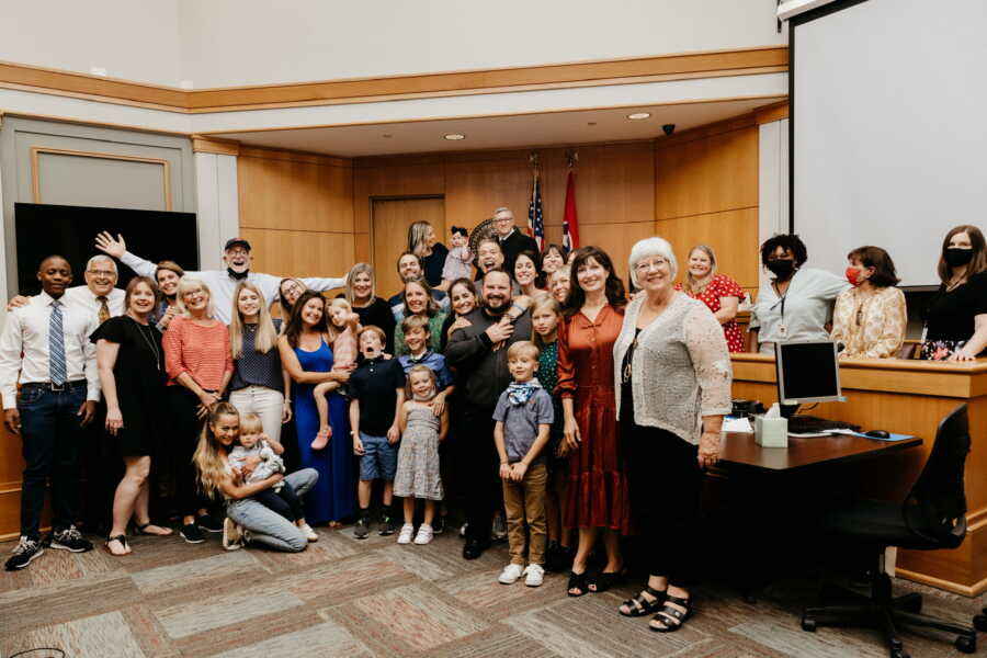 Single foster mom takes picture with support community.