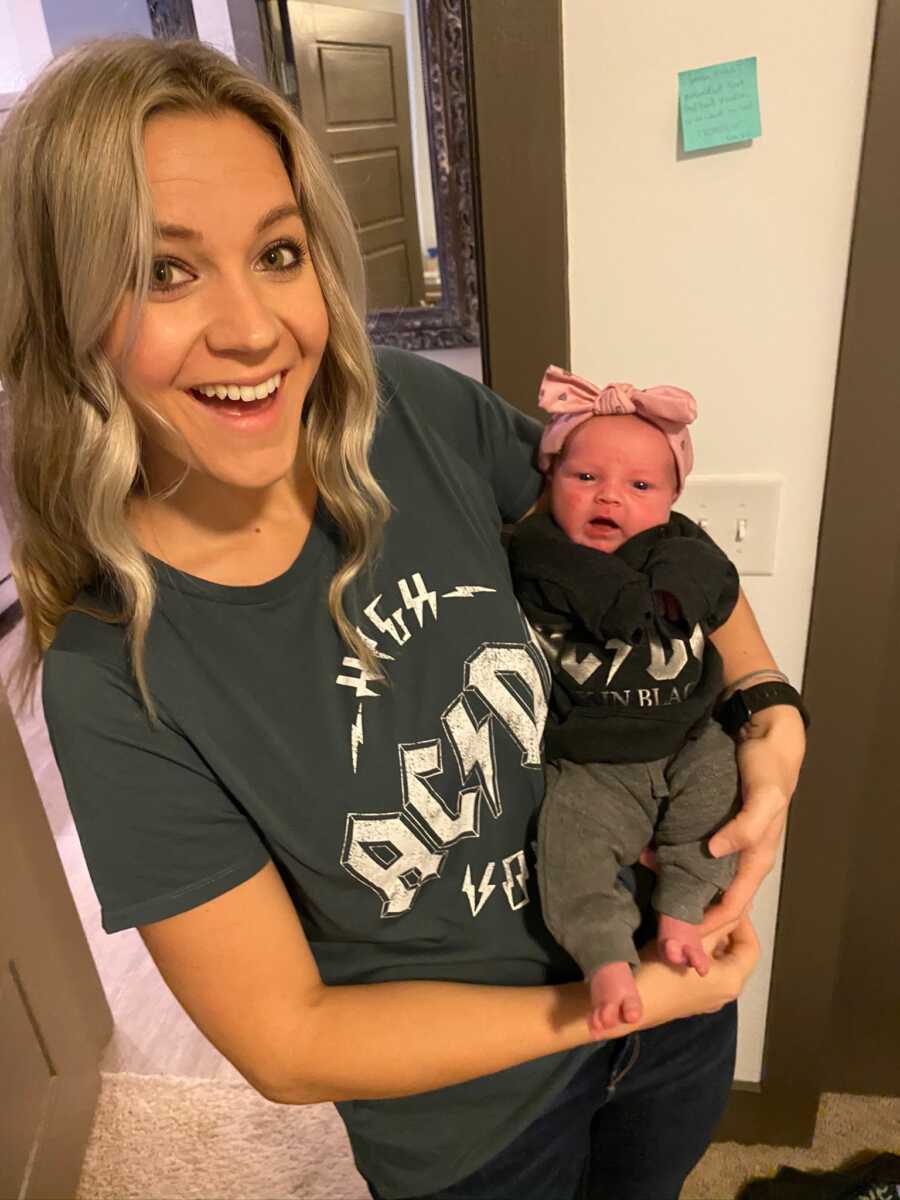 Single foster mom holds up baby girl with giant pink headband.