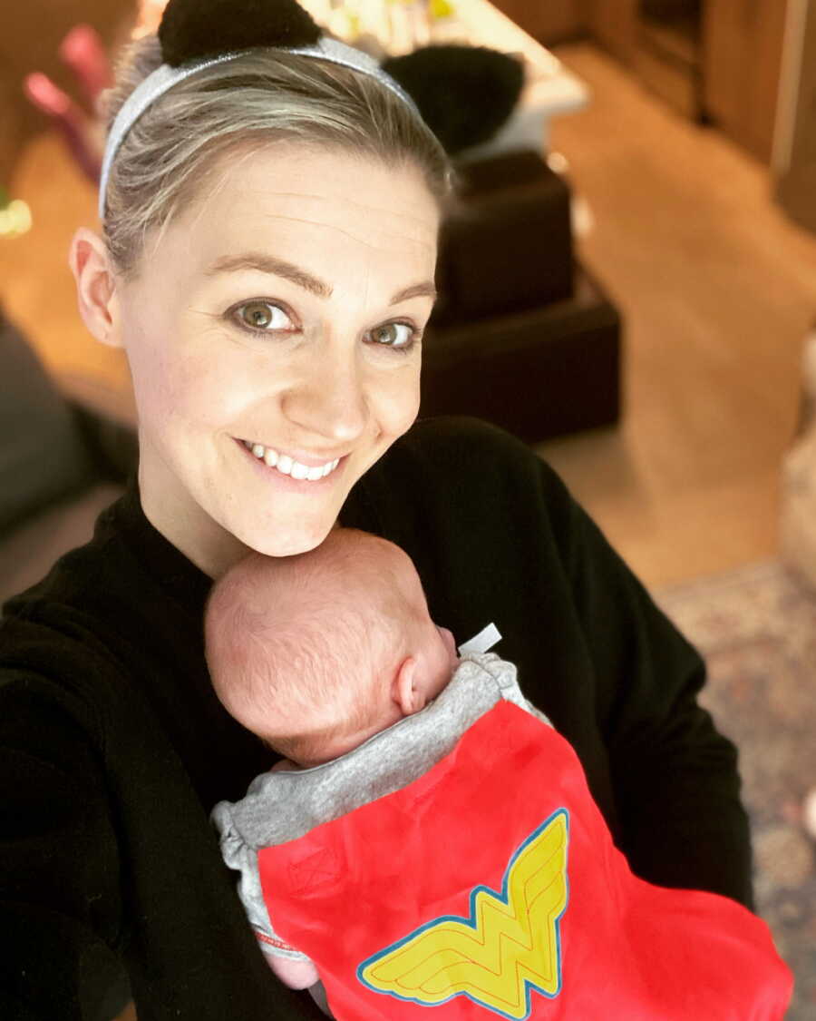 Single foster mom holds baby girl against her chest with her chin resting on the top of her head.