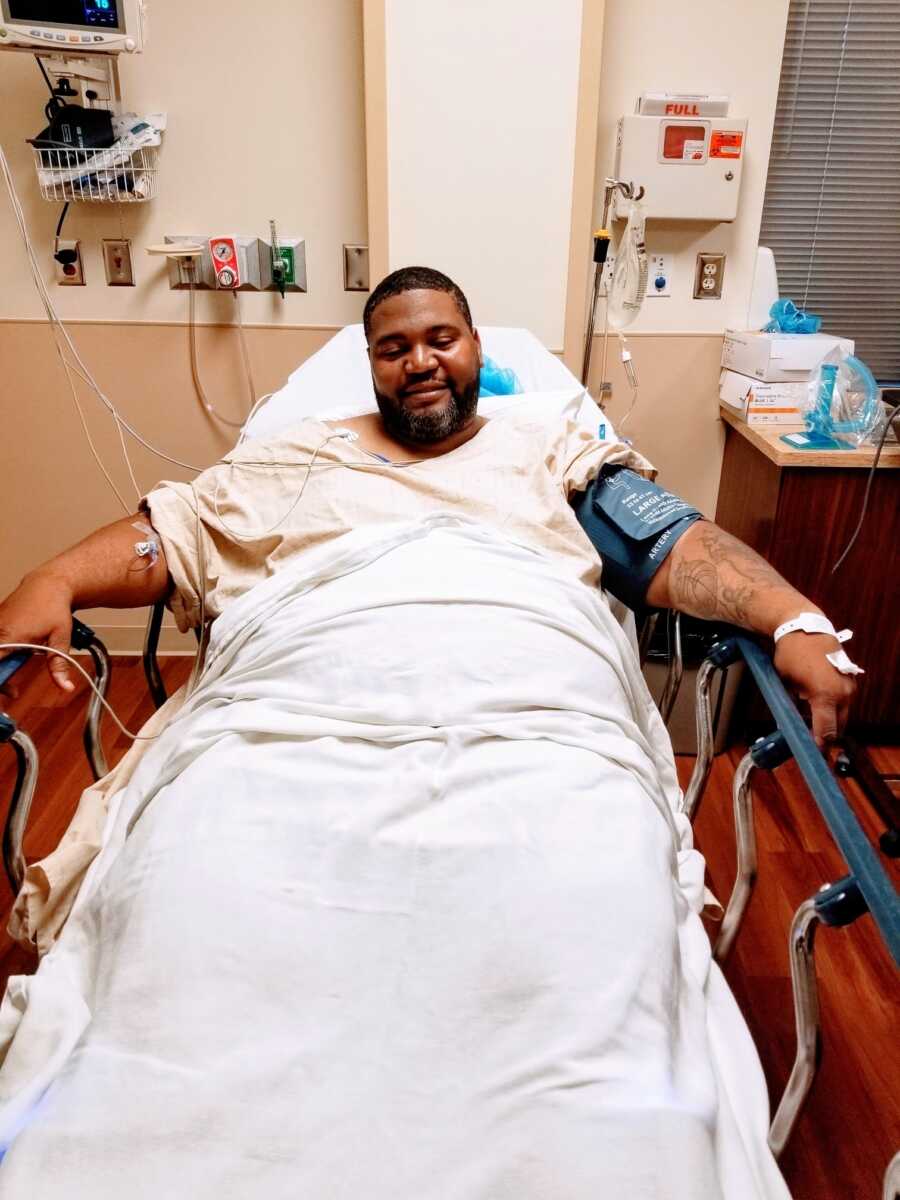 A man sitting in a hospital bed preparing for weight loss surgery