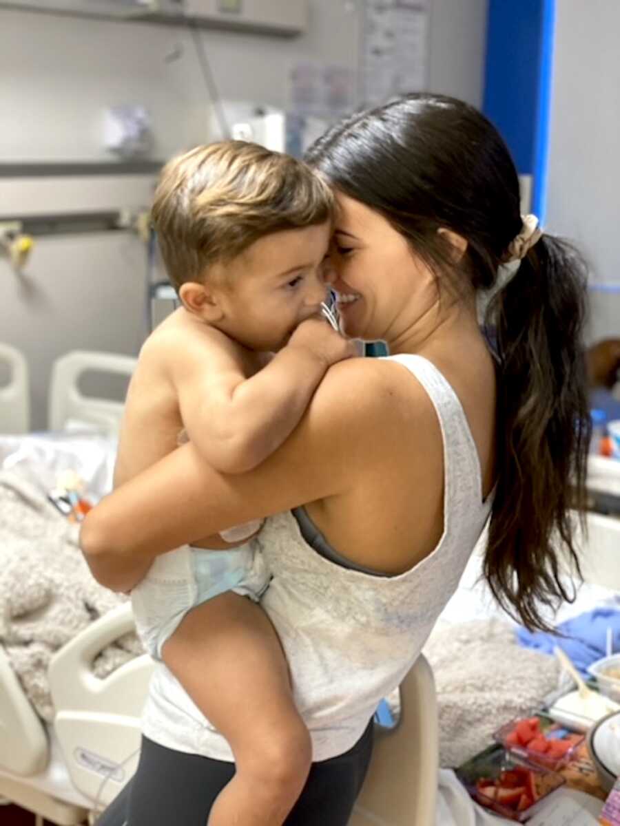 mom holds her son close while he is staying in the hospital