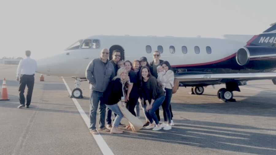 family greets group after flying home from hospital stay at airport