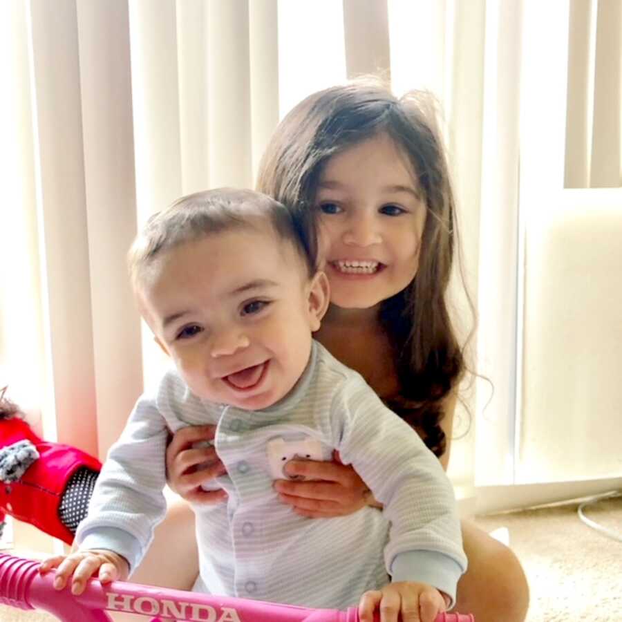 big sister holds her little brother