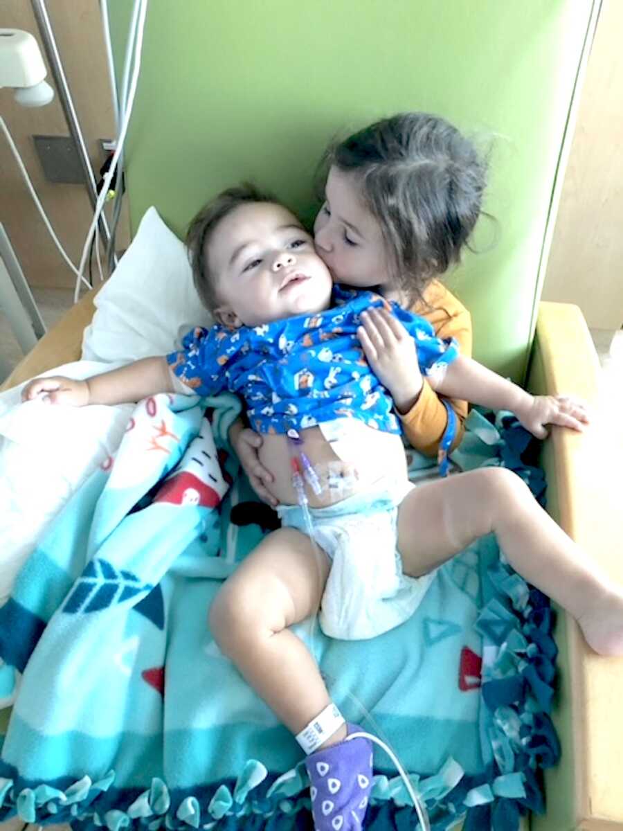 sister holds her brother on her lap