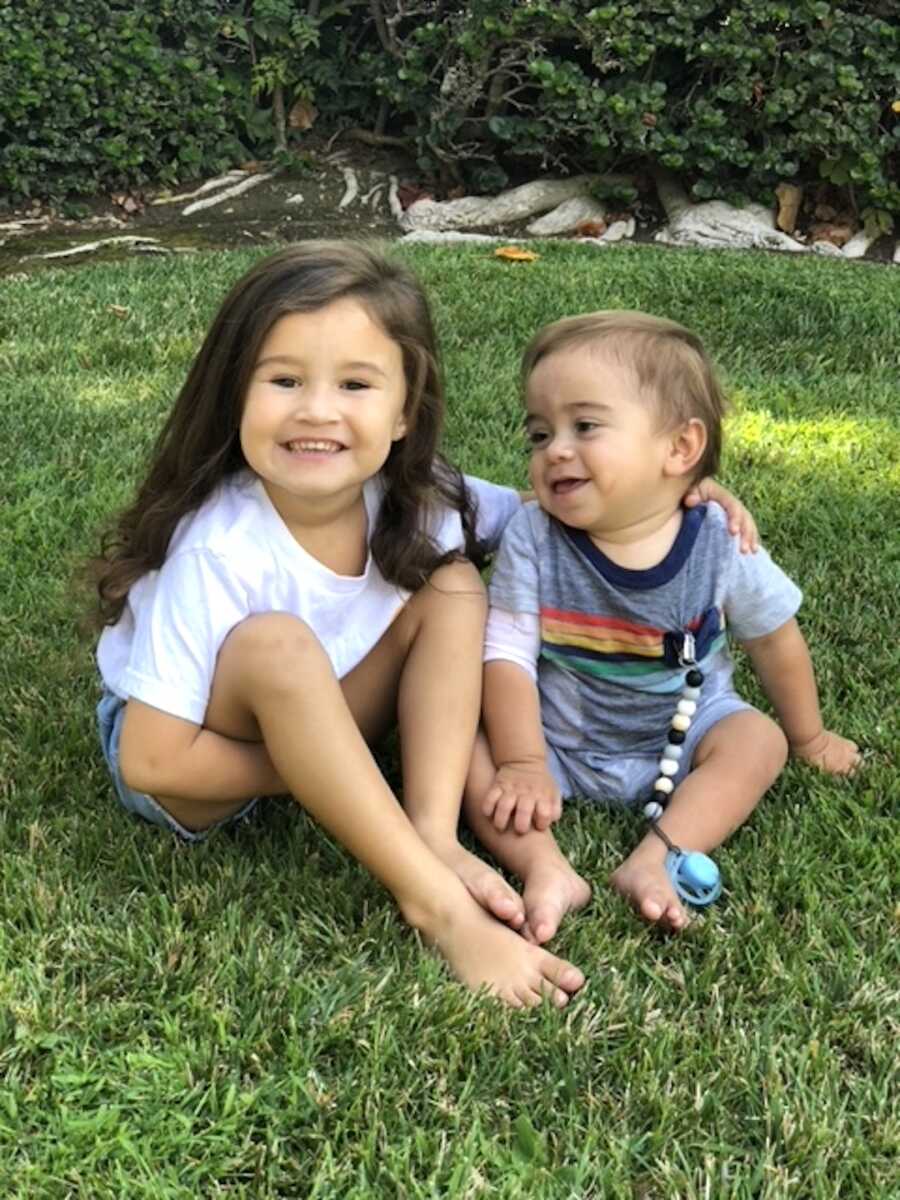 siblings sit outside with one another