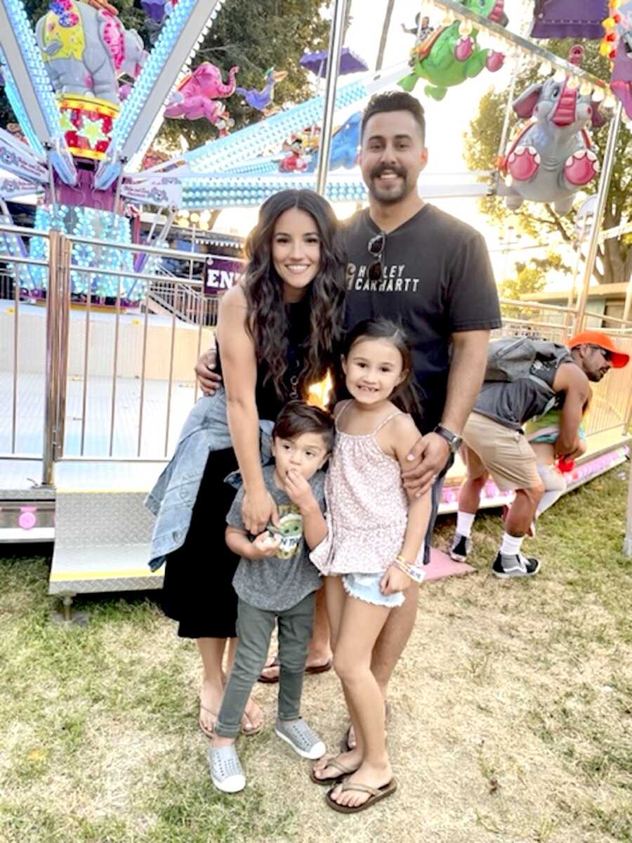 family stands together at a fair