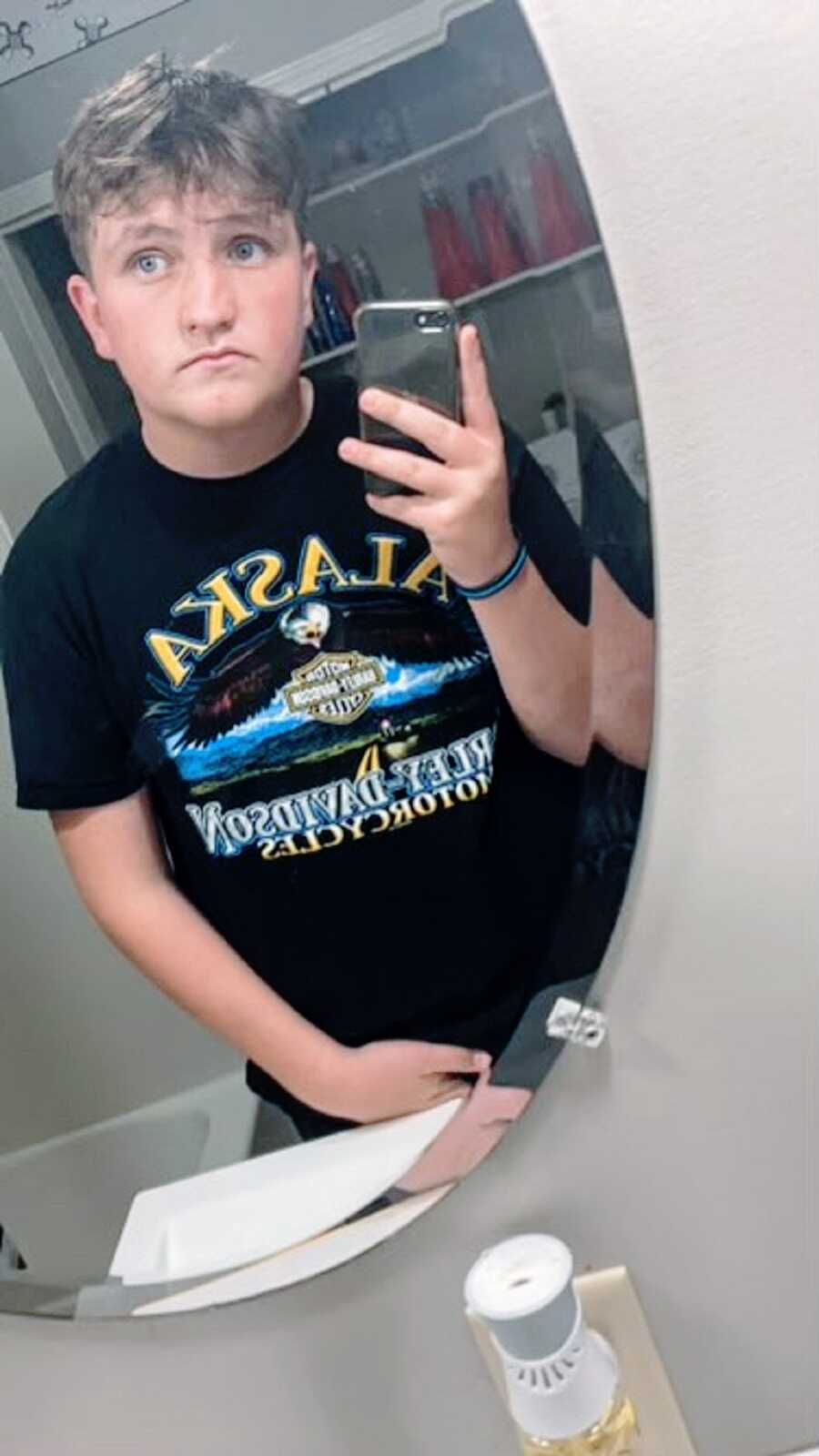 A boy who committed suicide takes a photo of himself in the bathroom mirror