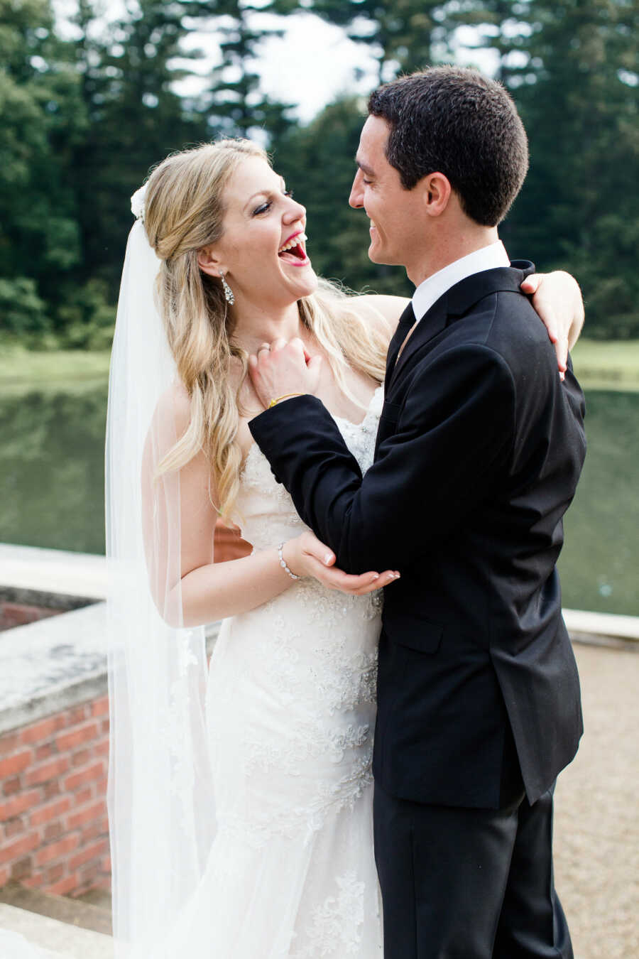 husband and wife smile and laugh together on their wedding day